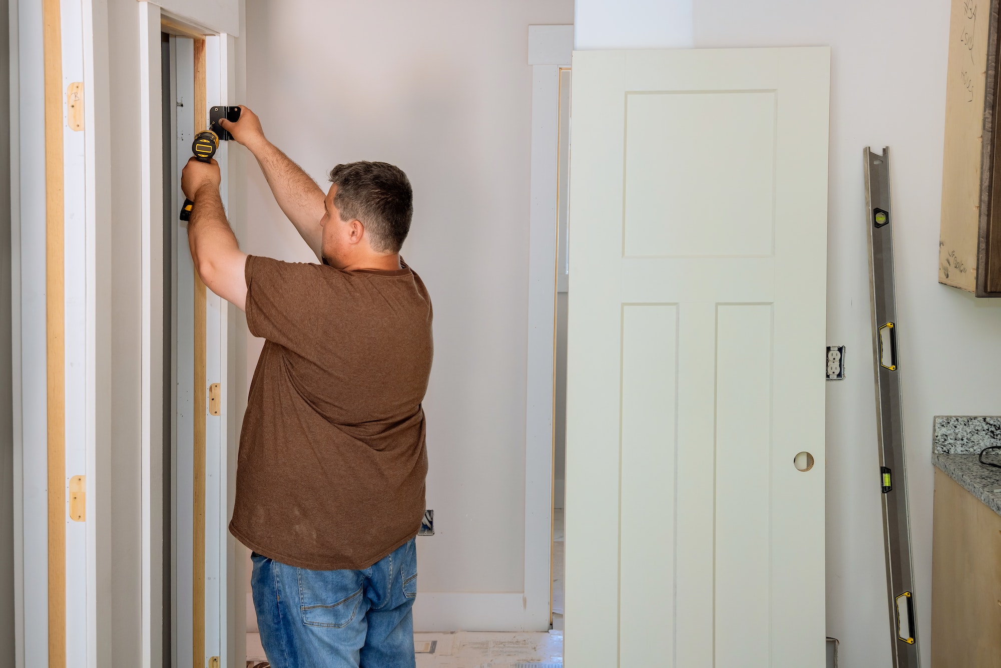 Installing the door hinge on the door frame using a screwdriver